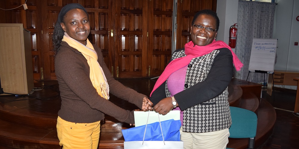 Ms. Hendrina Chalwe Doroba, outgoing Executive Director (right) receives a farewell gift from the Human Resources and Administration Officer Ms. Lilian Nanzala at a farewell party