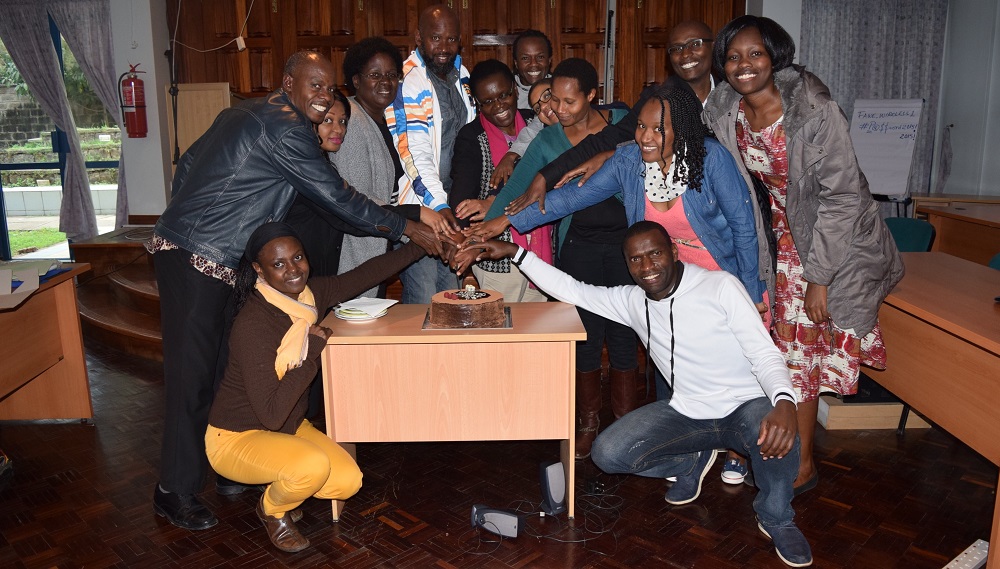 Staff at the FAWE Regional Secretariat in a cake-cutting group photo at Hendrina's farewell party